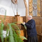 Ksiądz proboszcz Tadeusz Żdanuk prezentuje mechanizm pokrywy chrzcielnicy.