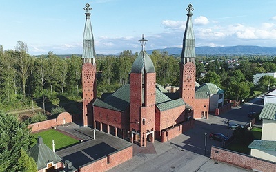 Sylwetka kościoła wpisana w otoczenie pobliskich domów.