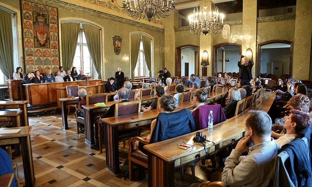 Poeci czytają Herberta w sali magistratu Krakowa.