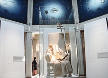 ▲	W centrum kolekcji znajduje się tron, a na nim papieska sutanna ułożona tak, jakby siedział tam Jan Paweł II.