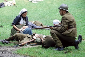 ◄	Sanitariuszka niosąca pomoc polskim żołnierzom na polu walki z Sowietami. Rekonstrukcja historyczna.