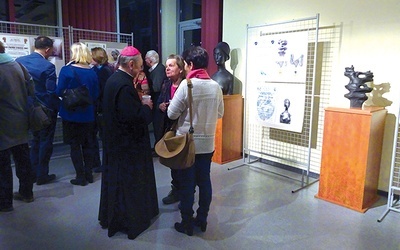 Biskup senior  na spotkaniu z twórcami. W tle wystawa „Sztuka Sacrum”.