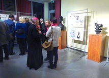 Biskup senior  na spotkaniu z twórcami. W tle wystawa „Sztuka Sacrum”.