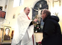 O. Rafał Sebastian Pujsza CP podaje relikwiarz do ucałowania.