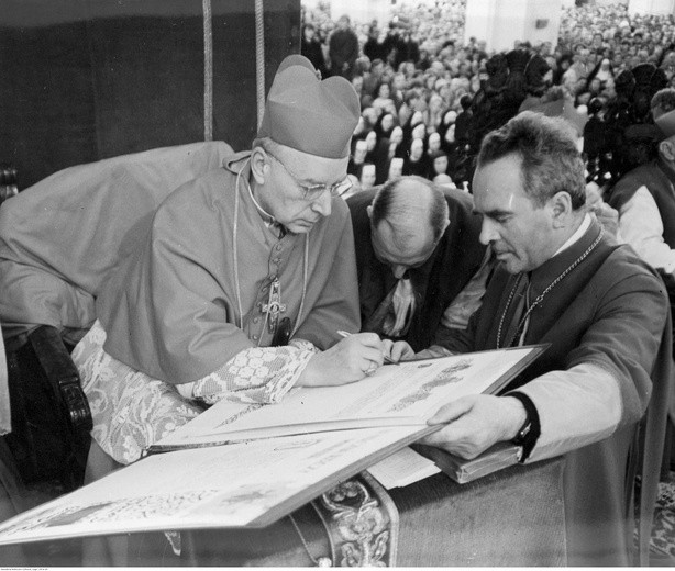 Gdańsk, 1966 r. Prymas Polski wpisuje się do Księgi Pamiątkowej. Widoczni także m.in.: ks. Hieronim Goździewicz (na prawo za ks. Prymasem) i proboszcz parafii Świętego Ducha w Gdańsku (przy bazylice Mariackiej) ks. Józef Zator-Przytocki (podtrzymuje księgę)