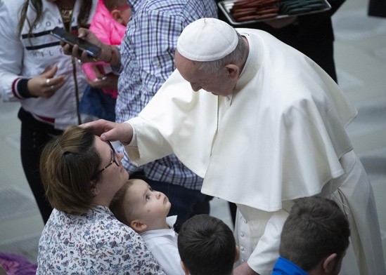 Papież Franciszek podczas audiencji błogosławi rodzinę