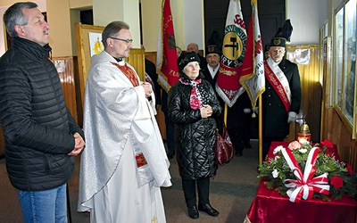 ▲	O. Mirosław Bożek z parafianami składa kwiaty pod tablicą upamiętniającą legendarnego kapłana.