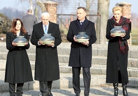 Uroczyste złożenie zniczy pod obozowym pomnikiem.