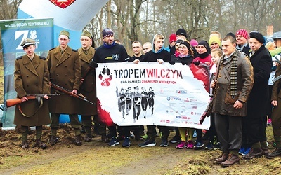 Uczestnicy Biegu Tropem Wilczym wraz z rekonstruktorami.