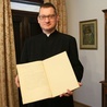 Ks. Wojciech pokazuje wpis błogosławionego w kronice parafialnej.