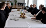 Biskupi i księża studenci przy wspólnym stole.