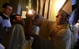 Biskup odpalający świecę od paschału.