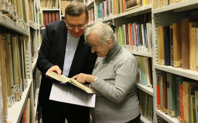 Kazimiera Dekraczewska i ks. prof. Mirosław Wróbel wsród księgozbioru biblioteki Wydziału Teologii KUL.