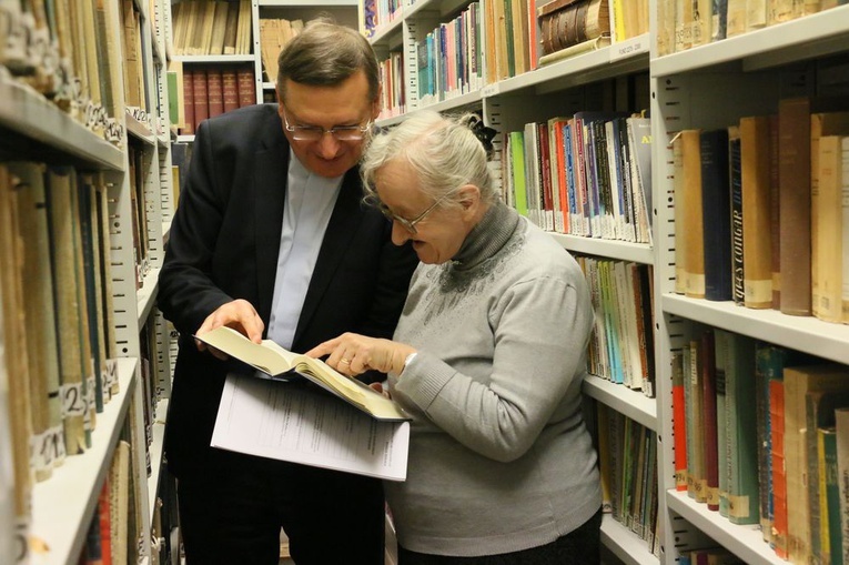 Kazimiera Dekraczewska i ks. prof. Mirosław Wróbel wsród księgozbioru biblioteki Wydziału Teologii KUL.