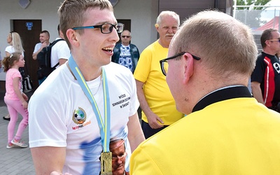 ◄	W gronie najlepszych biegaczy znalazł się Janusz Matysiak, kleryk świdnickiego seminarium. Na zdjęciu po nałożeniu przez ks. Krzysztof Orę pamiątkowego medalu.