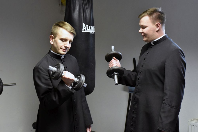 Sesja zdjęciowa neoprezbiterów w siłowni