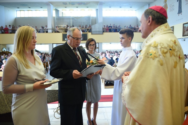 Parafianie witają bp. Jeża i przekazują mu symboliczny klucz do kościoła.