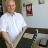 Ks. Andrzej Maleszyk pokazuje stare księgi, które opowiadają o historii kościoła.