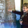 ▲	Prof. Joanna Kalaga omawia zdjęcie,  na którym widać fragmenty późnoromańskiego muru. Znajduje się on we wschodniej części obecnego kościoła.