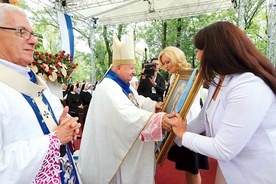 Kobiety przynoszą obraz Matki Bożej w procesji z darami.