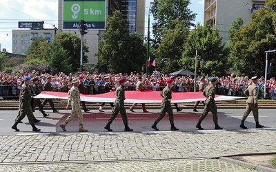 Przemarsz wojsk rozpoczęli żołnierze niosący flagę Polski.