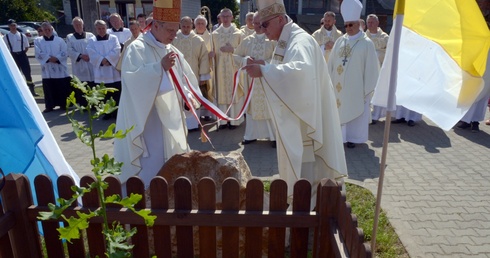 Kamień ustawiony przy dębie "Ludwik", który będzie żywą pamiątką obchodów, odsłonili biskupi Henryk Tomasik (z lewej) i Artur Miziński.