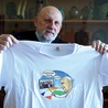 ▲	Ks. Krzysztof Czermak prezentuje koszulkę z logo wydarzenia.