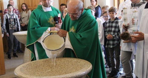 Kropielnice napełnił wodą ks. Stanisław Kosowicz. Obok stoi ks. Mariusz Krycia.