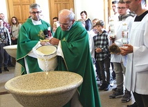 ▲	Granitowe naczynia napełnił wodą ks. Stanisław Kosowicz. Obok stoi ks. Mariusz Krycia.