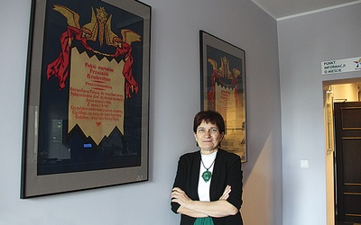 	Halina Bieda, dyrektor muzeum. Za nią jej ulubiony eksponat – plakat wydany w językach polskim i niemieckim, mówiący o wspólnej miłości do Górnego Śląska.
