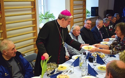 Biskup sandomierski podczas obiadu z osobami potrzebującymi.