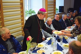 Biskup sandomierski podczas obiadu z osobami potrzebującymi.