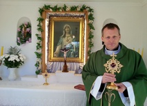 Ks. Piotr Drozd pookazuje relikwie świętych odnalzione w parafii.