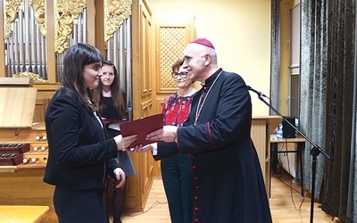 ▲	Biskup wręcza dyplom Weronice Mężyńskiej z parafii Ducha Świętego w Gliwicach-Ostropie, jednej z absolwentek gliwickiego SMK. 