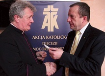 Ks. Zbigniew Samociak i Ryszard Furtak dzielą się opłatkiem.