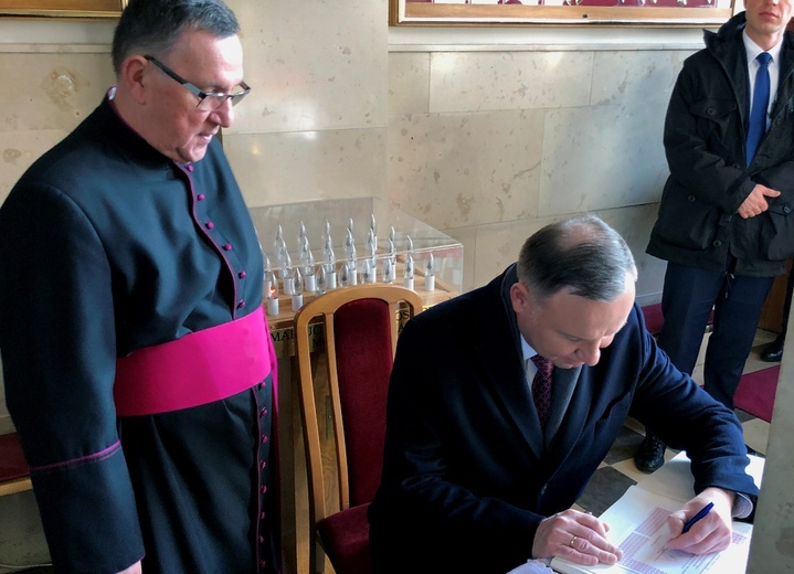 Prezydent wpisał się do księgi pamiątkowej sanktuarium. Obok ks. Jerzy Karbownik, kustosz sanktuarium.