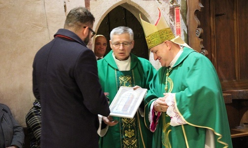 Bp Piotr Greger i ks. Zygmunt Siemianowski wręczają Medal św. Stanisława ministrowi Grzegorzowi Pudzie.