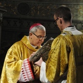 Bp Piotr całuje księgę Ewangelii w czasie liturgii.