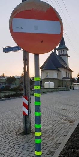 Odblaski na znakach drogowych w Leśnej. Idziesz o zmroku? Zabierz i oddaj w podobnym miejscu u swojego celu.