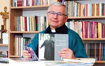 Ksiądz profesor prezentujący swoje publikacje.