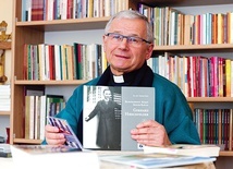 Ksiądz profesor prezentujący swoje publikacje.