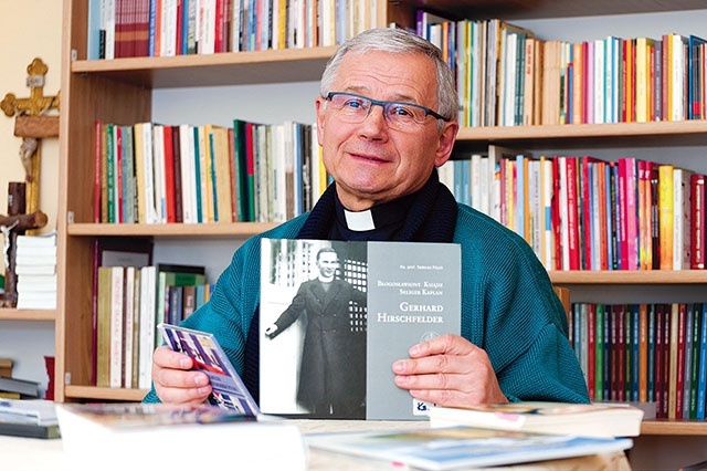 Ksiądz profesor prezentujący swoje publikacje.