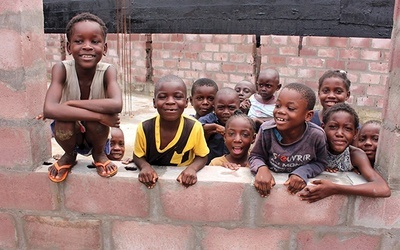 Dzieci przy jednej ze ścian budowanej szkoły.