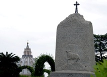 Kamienny monument przypominający o krzyżu na Giewoncie, ustawiony w Ogrodach Watykańskich z woli św. Jana Pawła II w 2001 r. W tle kopuła bazyliki św. Piotra.