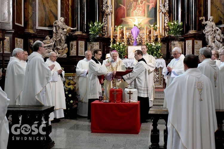 Księża z biskupem w trakcie poświęcenia krzyżma i pobłogosławienia olejów.