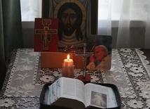 Ikona Chrystusa, otwarte Pismo Święte, płonąca świeca... tak może wyglądać miejsce rodzinnej modlitwy w czasie świąt wielkanocnych.