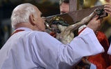 Bp Ignacy Dec całujący ramiona wiszącego na krzyżu Chrystusa.