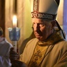 Biskup niosący świecę z zapalonym ogniem symbolizującym zwycięstwo życia nad śmiercią.