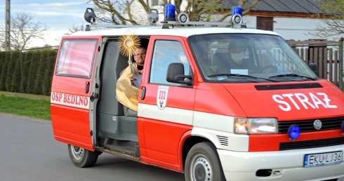 Kapłan z Chrytusem Eucharystycznym przemierzał ulice parafii wozem strażackim.