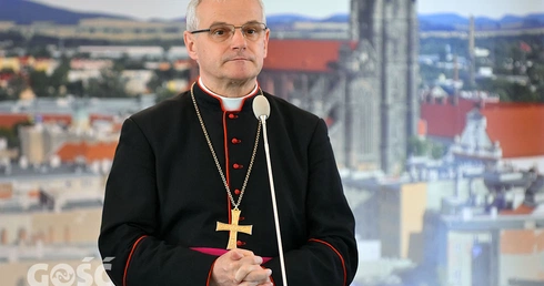 Biskup Marek Mendyk na tle świdnickiej katedry.